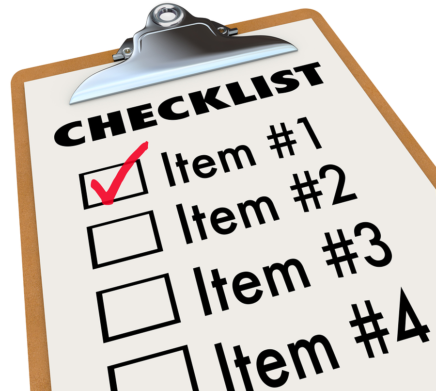 A checklist on a wood and metal clipboard with a check next to t